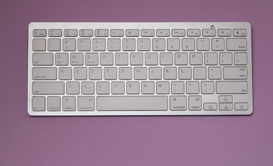 white keyboard on lilac background