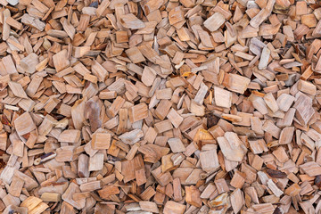 A pile of wood sawdust lies on the ground, background