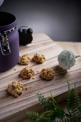 A chocolate chips cookies with jar, flower and retro clock as background
