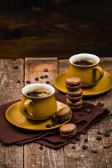 French Chocolate Macarons with Coffee Beans on Wooden Table. Selective focus.