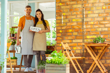 Two partners standing in front of their flower shop.