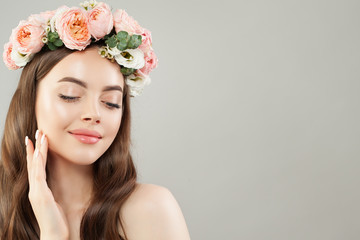 Young beauty. Beautiful woman with clear skin, long hair and flowers