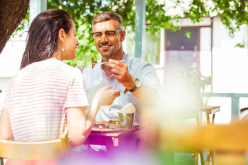 Happy married couple having lunch at summer cafe.