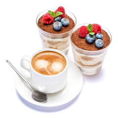 Cup of cofee and Classic tiramisu dessert with blueberries and raspberries in a glass isolated on a white background with clipping path