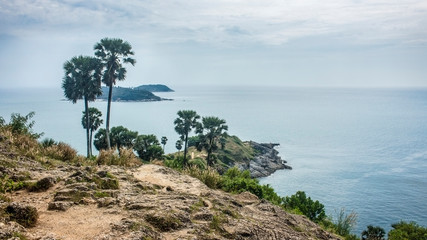 Beautiful landscape of the Promthep Cape, with palm trees and the Andaman sea in a cloudy day. With copy space.