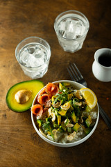 Healthy rice bowl with avocado, salmon and cashew nuts