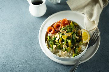 Healthy rice bowl with avocado, salmon and cashew nuts