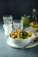 Healthy rice bowl with avocado, salmon and cashew nuts
