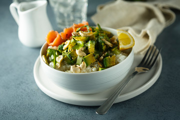 Healthy rice bowl with avocado, salmon and cashew nuts