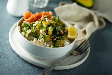 Healthy rice bowl with avocado, salmon and cashew nuts