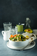 Healthy rice bowl with avocado, salmon and cashew nuts