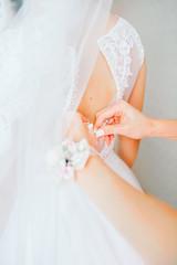 Wedding dress close-up hands knotted corset bride.