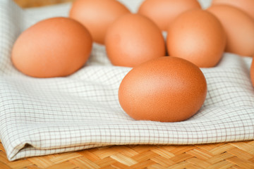 Brown eggs lay on a white plaid fabric. Healthy food concepts.