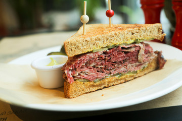 Pastrami sandwich with mustard and red wine