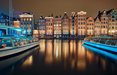 Brick houses and canal in amsterdam at night