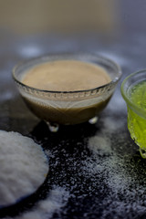 Rice flour and rice grain on wooden surface along with some green tea in a transparent glass cup and a star anise in it.Face mask for the treatment for smoother skin.