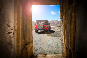 Stone window and red summer car. Free space for your decoration and sunny day. 