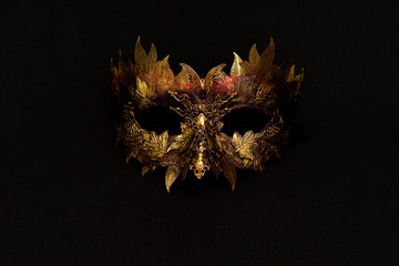 Venetian mask in gold and red with metallic pieces in the form of leaves. original and unique design, handmade crafts - obrazy, fototapety, plakaty