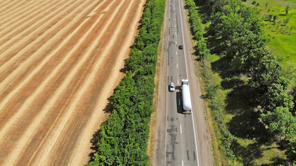 Aerial. Gasoline tanker driving by the highway. View above.