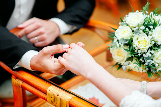 Interracial couple holding hands sit at cafe table, african black man and white woman in love enjoy date in coffee house concept, romantic biracial lovers meet in public place together, close up view