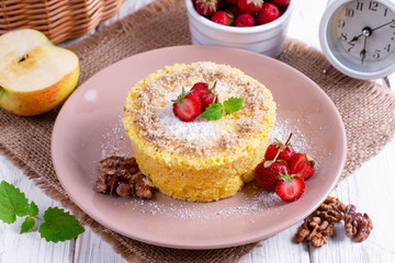 Home sponge cake, decorated with strawberries and mint closeup on the table