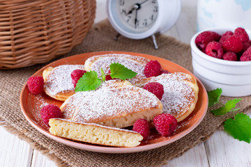 Fototapeta na wymiar Pancakes with powdered sugar and fresh raspberries