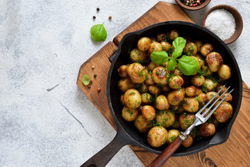 Fried, young potatoes with basil in a pan. View from above.