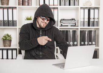 Man hacker using laptop in office
