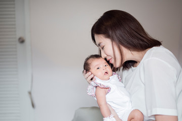 Beautiful woman holding a newborn baby in her arms