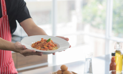 Obraz na płótnie Canvas Cropped view of man preparing a delicious healthy spaghetti tomato sauce and presentation food