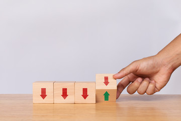 Hand flip wooden cube with down arrow to arrow pointing up on white background. Concept of growth and success or rising successful development and business development in the future