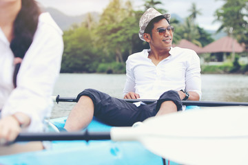 A handsome young man is sitting in a kayak comfortably and relax on a vacation.