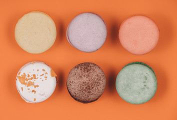 Obraz na płótnie Canvas Top view of set macaron on soft orange or coral paper background. Traditional french dessert. Delicious food