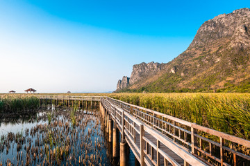 Obraz premium Wooden Bridge in the lake and mountain lanscape on sunset at Khao Sam Roi Yot National Park, Thailand.