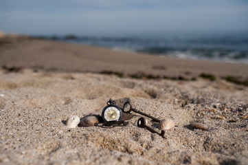 Pocket watch in sands on beach
