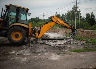 excavator at the construction site. perforator. yellow tractor produces construction work. to destroy concrete.