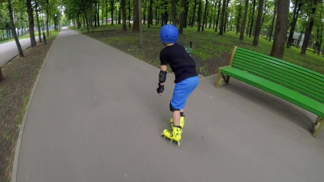 Sport rollerblade hobby. Fast inline skating. Boy speeding through the park.