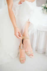 Beautiful female legs in stylish shoes on a high heel, the bride puts on wedding shoes on high heel