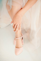 Beautiful female legs in stylish shoes on a high heel, the bride puts on wedding shoes on high heel