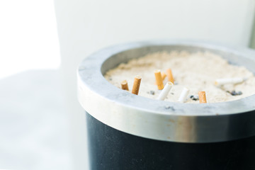 Smoked cigarettes in sandy ashtray