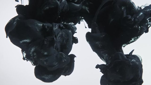 Black nacreous paint in water against white background.