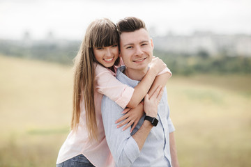 Happy young couple hugging and laughing outdoors. Love and tenderness. Lifestyle concept