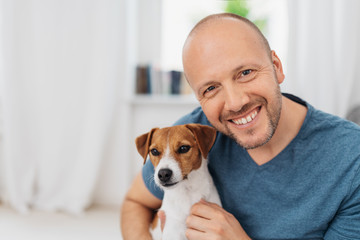 lachender Mann umarmt seinen Hund