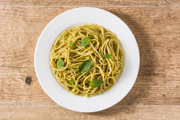 Spaghetti pasta with pesto sauce on wooden table