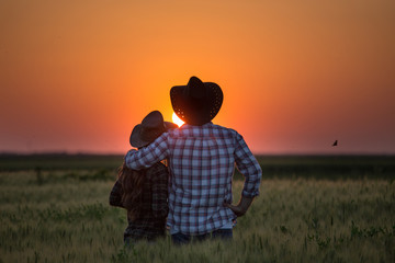 Couple looking at sunset in field