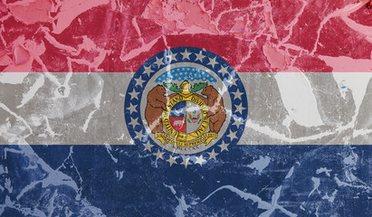 The national flag of the US state Missouri in against a gray wall with cracks and faults on the day of independence in blue red and white. Political and religious disputes, customs and delivery