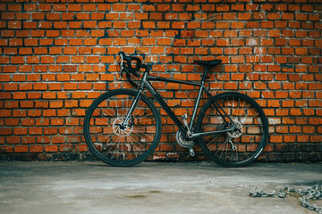 City bicycle stading againist the background of red brick wall.