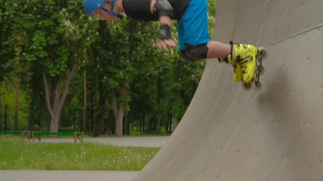 Sports training. Roller boy gathering speed on a ramp for his next trick