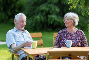 Old couple drinking tea in park