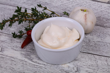 Mayonnaise sauce in the white bowl served thyme and garlic